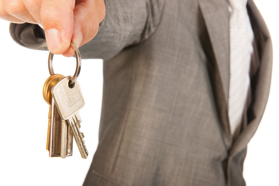 Säljare står med nyckeln till ditt nya hus